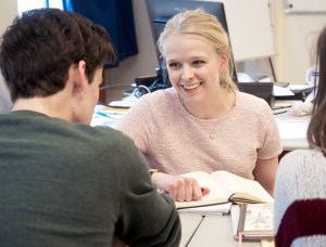 Docent helpt leerling bij de SSL, de Leidse Examentraining