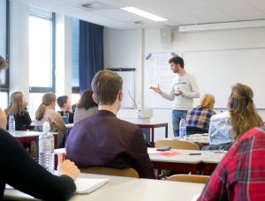 Docent geeft klassikale uitleg economie examentraining SSL