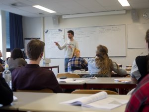 Docent staat voor de klas bij de examentraining bedrijfseconomie SSL. 