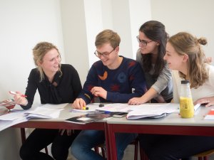 Een groepje leerlingen overlegt bij de examentraining economie van SSL